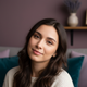 Portrait of a young woman smiling peacefully, conveying satisfaction and tranquility.